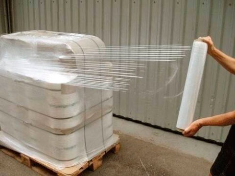 Filme stretch sendo aplicado em pallet para proteção e fixação de cargas